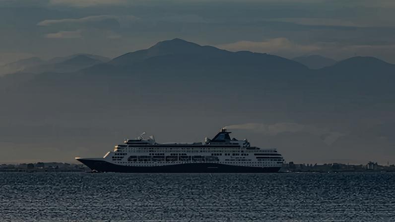 O navio de passageiros Celestyal Cruises navegando perto de Tessalônica, com o Monte Olimpo ao fundo
