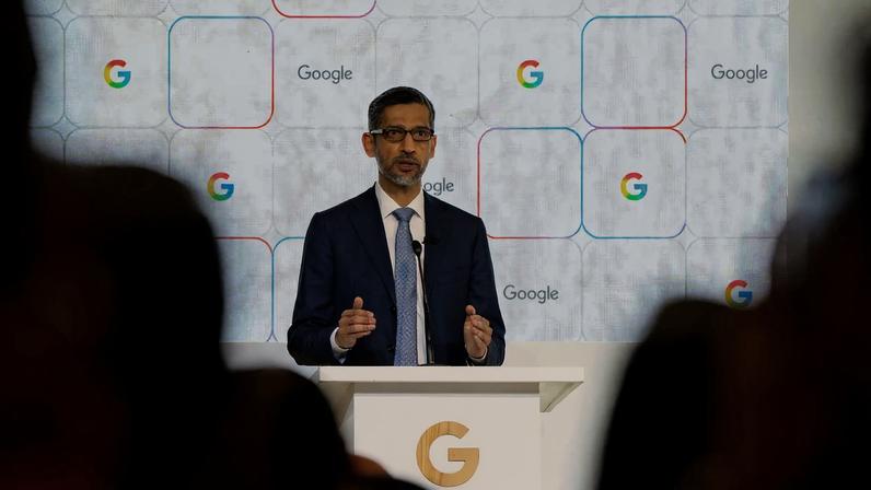 Sundar Pichai gesturing with both hands as he addresses the crowd