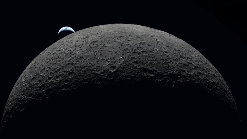 Detailed view of the moon's surface with a small sliver of earth peeking from behind