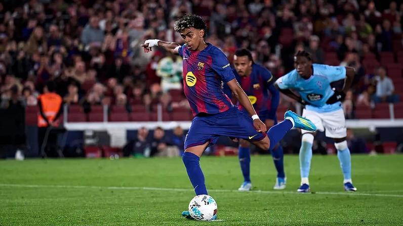 Lamine Yamal em campo, prestes a chutar bola.