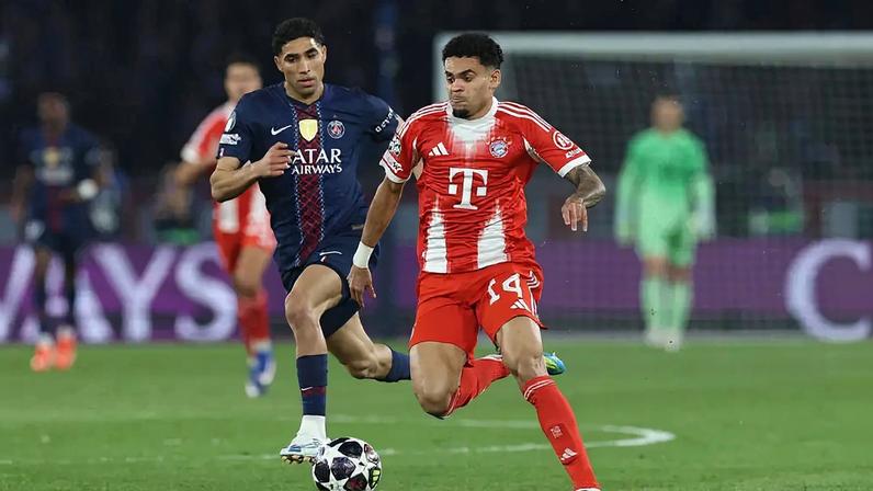 IDA - Luis Diaz, do FC Bayern de Munique, corre com a bola sob pressão de Achraf Hakimi, do Paris Saint-Germain, durante o jogo de ida da semifinal da Champions League - (Alexander Hassenstein/Getty Images)