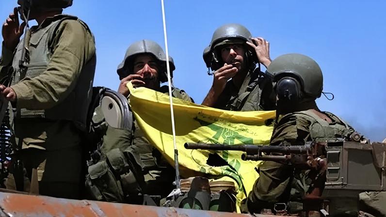 Soldados israelenses mostram uma bandeira do Hezbollah quando voltam da ação contra os guerrilheiros do Hezbollah no sul do Líbano, 25 de julho de 2006, na fronteira israelo-libanesa, perto da comunidade de Avivim