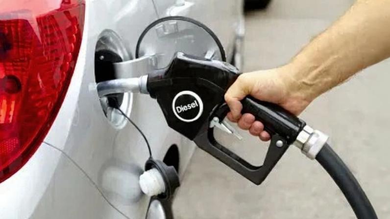 Man filling car with diesel at garage.