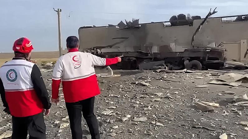 Integrantes do Crescente Vermelho em frente a armazém de suprimentos no Irã.