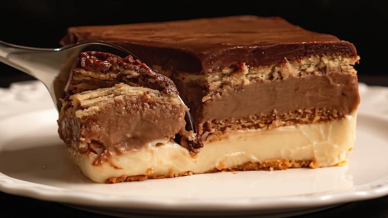 Pavê de chocolate sendo cortado com uma colher. Foto: Victor/ Adobe Stock