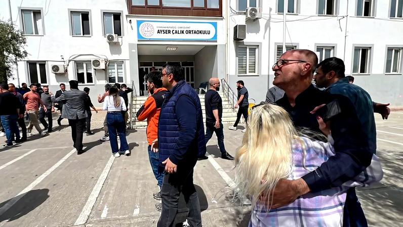 Pessoas esperam em frente ao prédio da escola após ataque no sudeste da Turquia