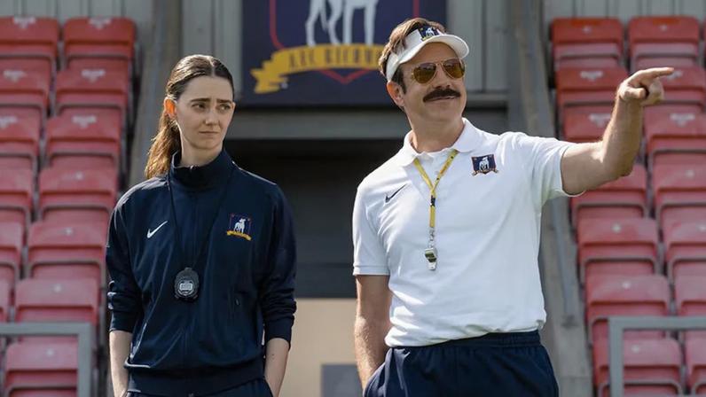 Tanya Reynolds e Jason Sudeikis em cena da quarta temporada de 'Ted Lasso', onde técnico norte-americano comandará time de futebol feminino inglês