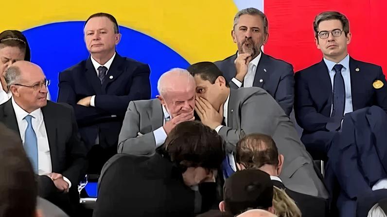 O presidente Luiz Inácio Lula da Silva (PT) conversa ao pé do ouvido com o presidente do Senado, Davi Alcolumbre (União-AP), durante evento no Palácio do Planalto