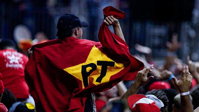 Manifestante segura bandeira do PT durante Congresso da UNE, em 2023