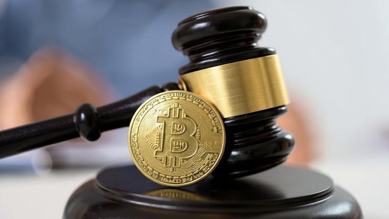 Martelo de juiz usado em tribunal e na corte com advogados na frente de uma moeda de bitcoin