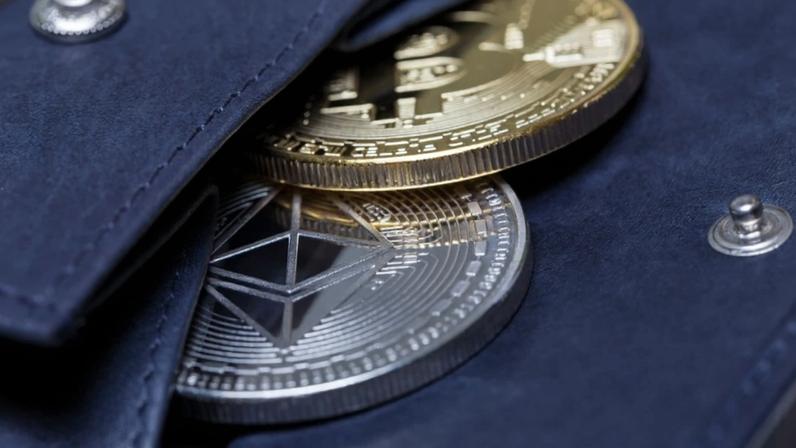 Moedas de Bitcoin e Ethereum à mostra em uma carteira de couro