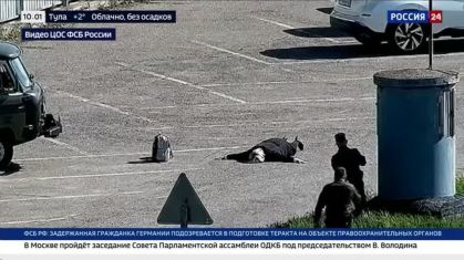 Mulher alemã deitada em estacionamento com mochila ao lado, na Rússia
