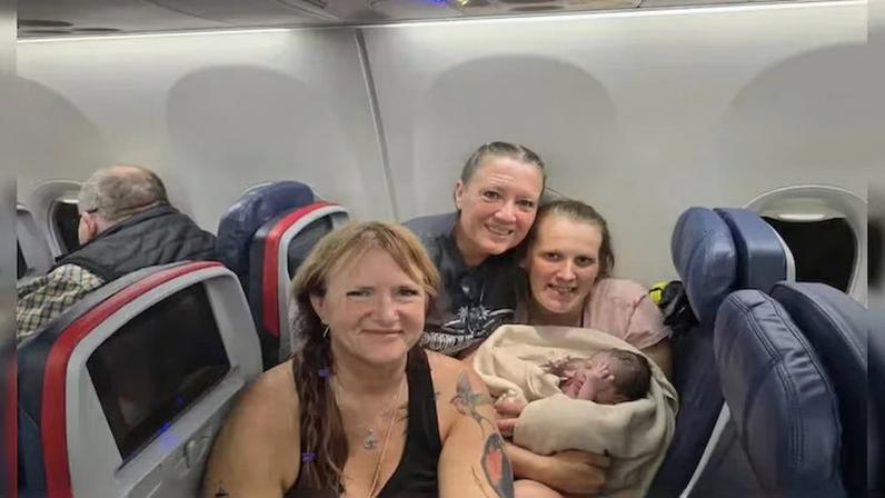 O bebê junto à equipe que auxiliou no parto a bordo