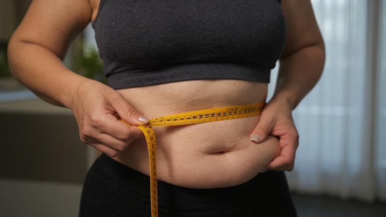 Mulher medindo a barriga com fita métrica - Gordura localizada: como o organismo escolhe o que queimar - Metrópoles