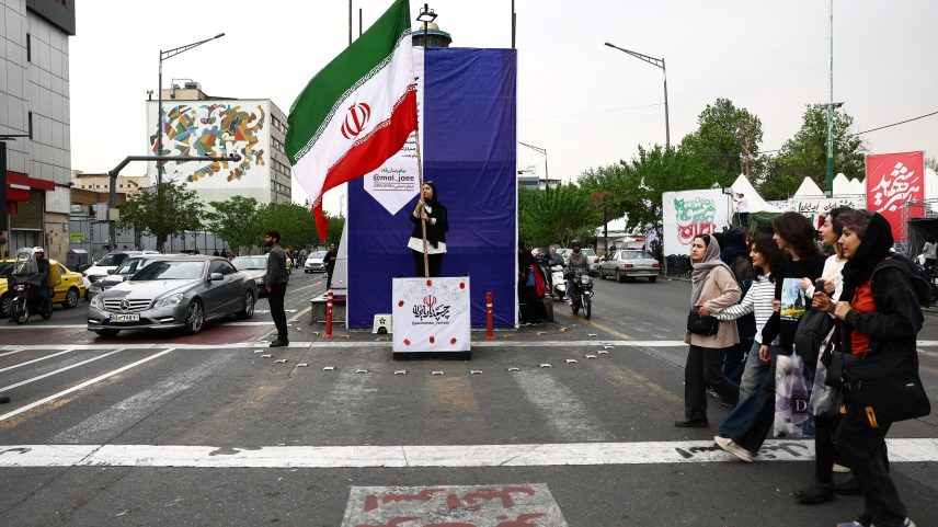 Mulher segura bandeira iraniana em meio a um cessar-fogo entre os EUA e o Irã, em Teerã