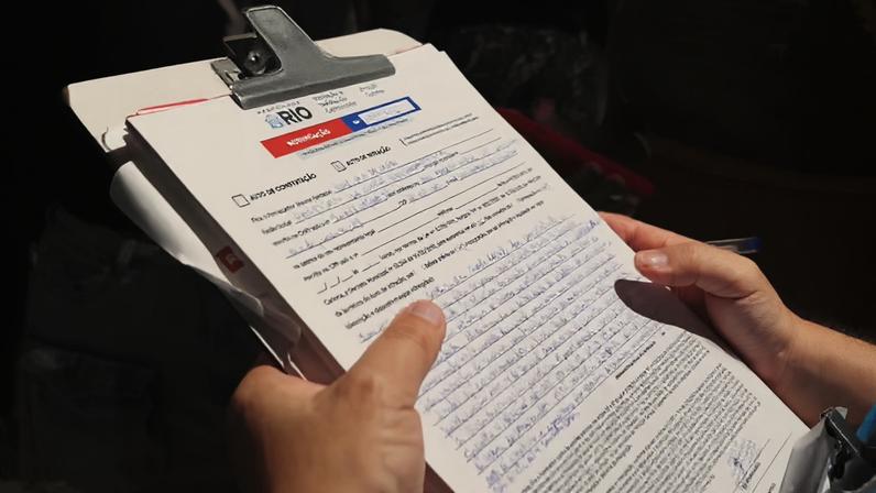 Pessoa segurando prancheta com documento do bar Partisan, no Rio de Janeiro