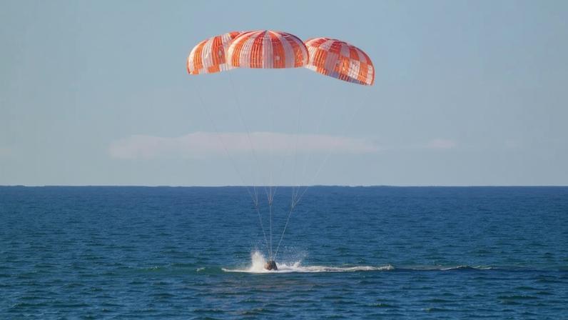 A espaçonave Orion da NASA, com os tripulantes da Artemis II a bordo é vista sob paraquedas ao pousar no Oceano Pacífico, próximo à costa da Califórnia.