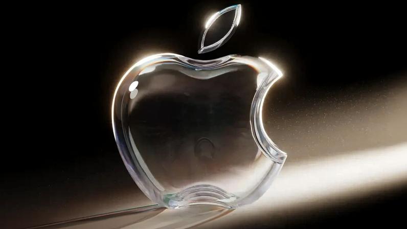Imagem, em fundo escuro, de uma maçã feita de acrílico transparente. Logotipo da Apple feito em vidro transparente.