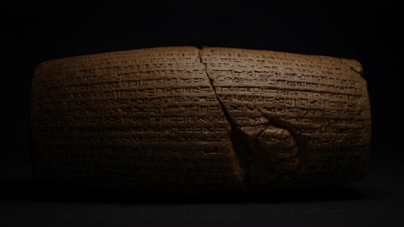 Imagem de um cilindro de pedra com escritas cuneiformes.