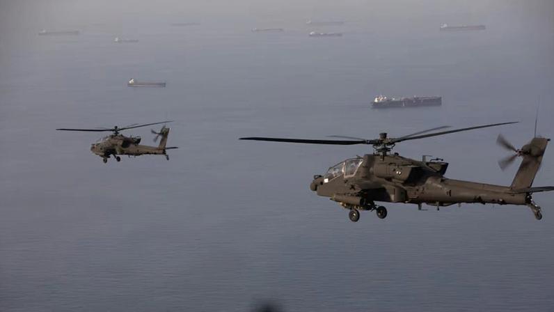 Os AH-64 Apaches voam acima do Estreito de Ormuz durante um patrulhamento, em 17 de abril 2026 . Soldados do Exército dos EUA estão voando dentro e ao redor do estreito, proporcionando uma presença visível em apoio à liberdade de navegação