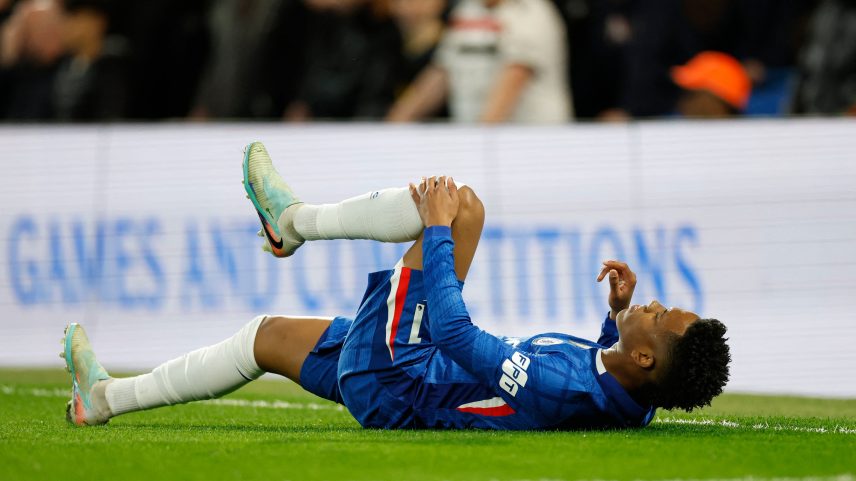 Estêvão caído no gramado após sentir lesão muscular na derrota do Chelsea para o Manchester United, na Premier League