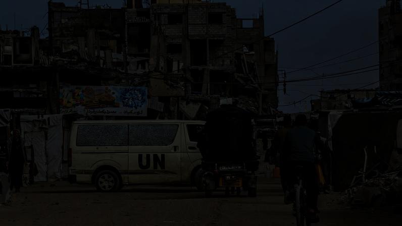 Um veículo da ONU e moradores palestinos são vistos em uma área fortemente destruída de Khan Yunis, no sul da Faixa de Gaza, - Foto: Getty Images