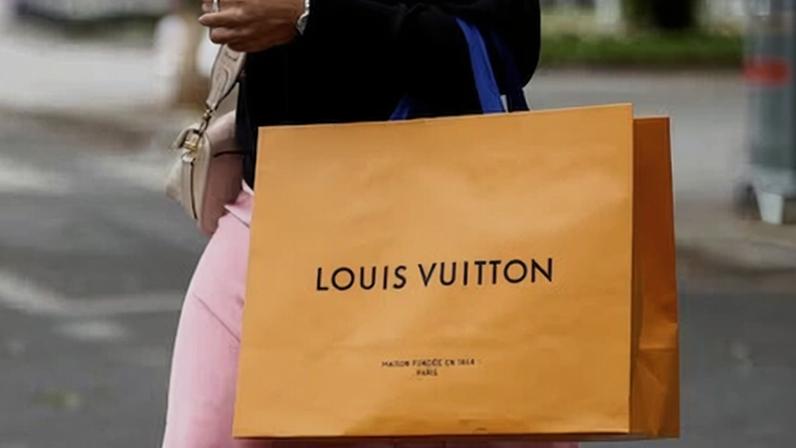 Una mujer camina con una bolsa de compras de Louis Vuitton en París. REUTERS