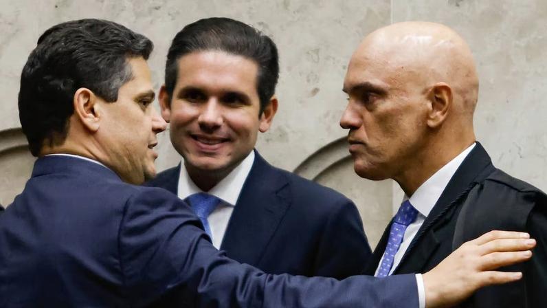 Davi Alcolumbre e Alexandre de Moraes se cumprimentam, observados pelo presidente da Câmara Hugo Motta