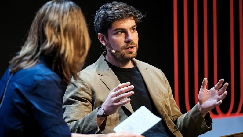 Max Jaderberg gestures with his hands while being speaking