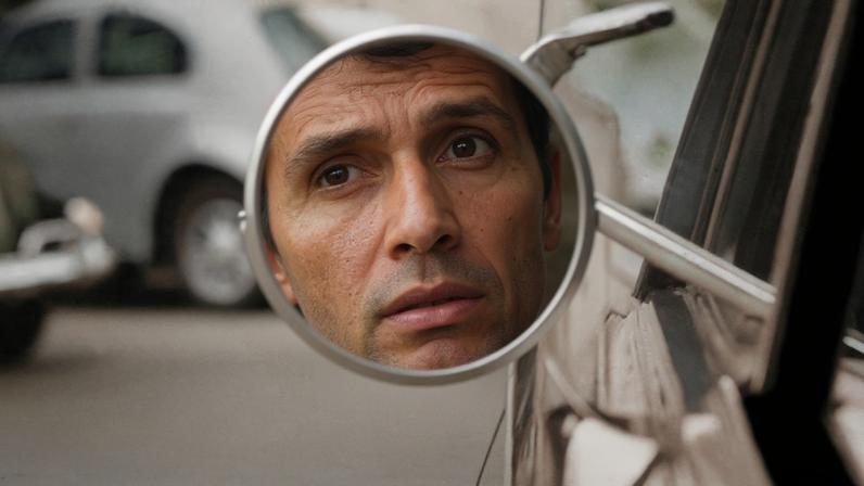 Reflexo do rosto do cantor e compositor Roberto Carlos no retrovisor de seu carro em 1967.