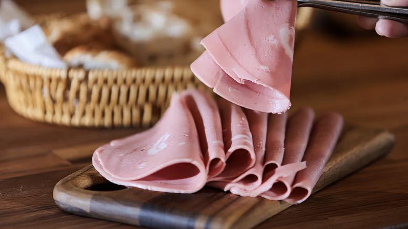 Mortadela em cima de uma mesa com pedações de pães. Foto: Werther Santana/Estadão