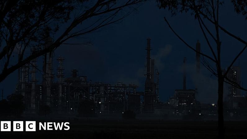 An oil refinery with smoke seen billowing out from several areas