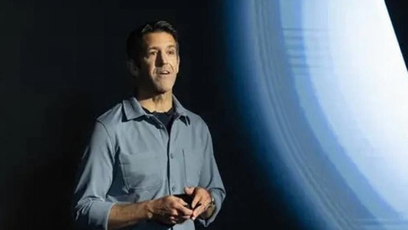 Getty Images John Ternus standing on stage in front of an Apple logo. He is wearing a grey shirt.
