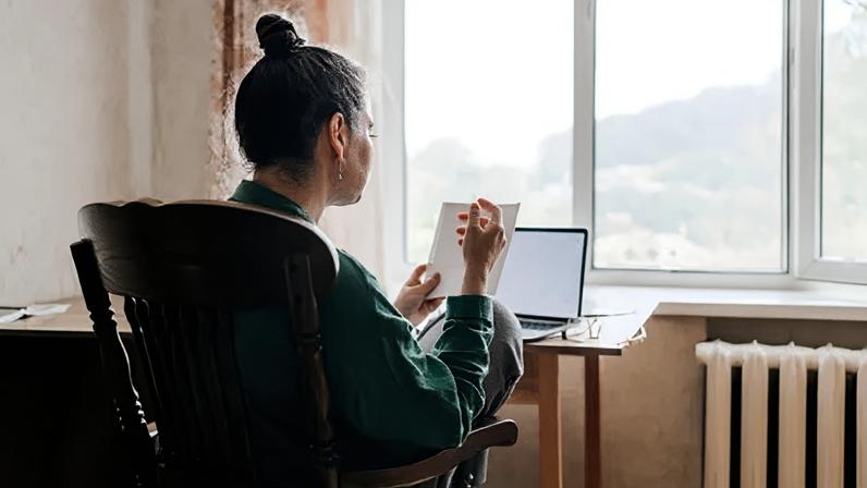 Getty Images A woman from the back sitting in front of a laptop