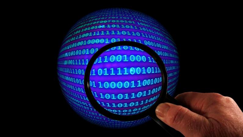 Magnifying glass over digital binary code as automated AI vulnerability discovery is reversing the enterprise security costs that traditionally favour attackers.