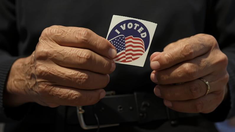 Eleitor mostra adesivo normalmente distribuído como brinde após o voto nos EUA — Foto: Eric Gay/AP