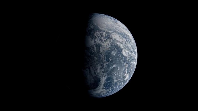 Image of Earth split by the terminator line. The terminator divides Earth’s surface diagonally, shrouding the top left half in darkness. Earth’s illuminated surface is mostly blue and covered in swirling white clouds.