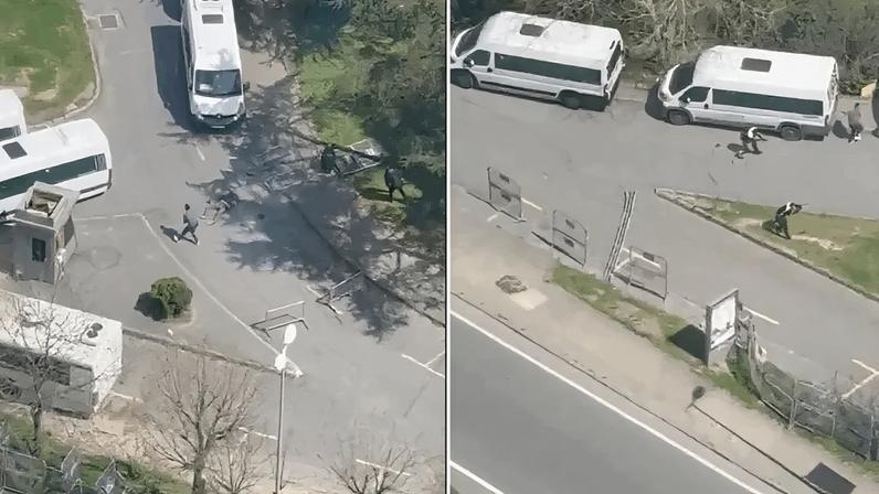 Na imagem, um homem armado com rifle e pistola disparando enquanto se movia entre veículos da polícia
