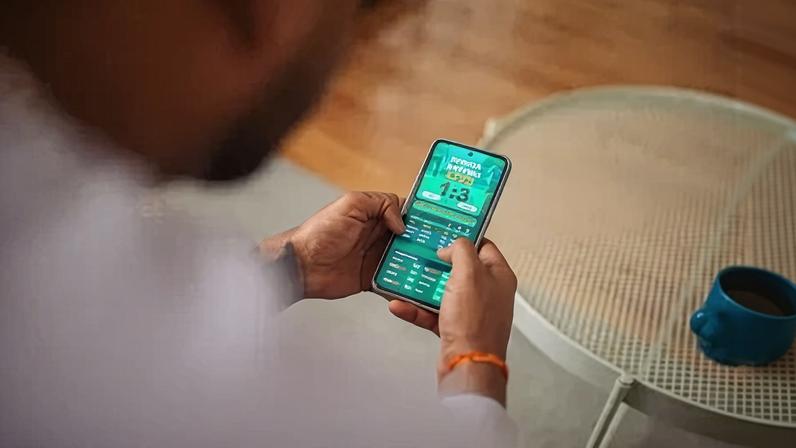 Pessoa usa smartphone para apostas esportivas