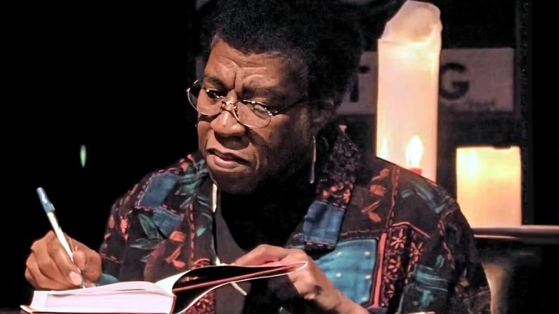Octavia Estelle Butler autografando exemplar de livro.