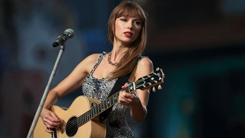 Getty Images Taylor Swift on stage playing a pink guitar in a sparkly top