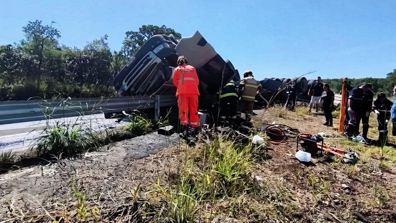 Carreta carregada de minério tombou e motorista ficou preso às ferragens na MG-050