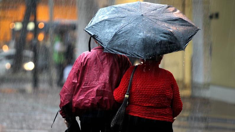 Pedestres se protegem do frio e da chuva em BH