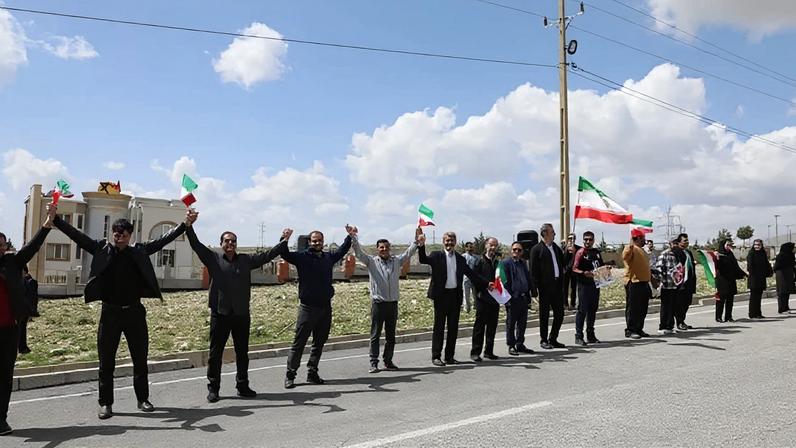 Na imagem, iranianos fazem corrente humana para defender infraestrutura do país