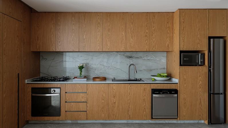 O conceito de cozinha linear se refere a um layout em que todos os elementos principais — pia, fogão, geladeira e armários — ficam alinhados em uma única parede, criando um espaço prático e funcional