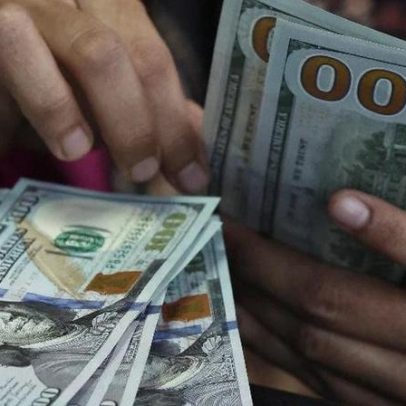 Dólar cai para R$ 4,98 e bolsa recua à espera de decisão sobre juros
