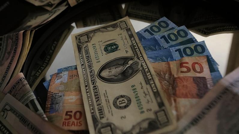 Articulista afirma que a melhor resposta para as tarifas externas é o fortalecimento da política comercial interna; na imagem, notas de dólar e real