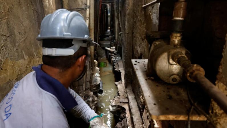 Funcionários da empresa privada Águas do Rio trabalham na infraestrutura de tratamento do esgoto na comunidade Nova Holanda, na capital fluminense