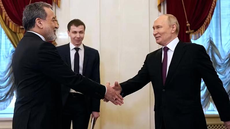 Putin (à dir.) cumprimenta chanceler iraniano Araqchi, em Moscou. e promete apoio a Teerá por fim da guerra — Foto: Dmitri Lovetsky/AP/Pool