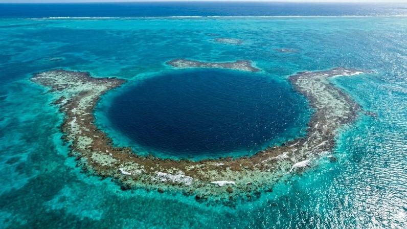 O Grande Buraco Azul (Great Blue Hole) é o maior sumidouro marinho do mundo, atraindo exploradores em busca de um sistema de cavernas escuras